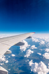 Obraz premium View from the airplane window at a beautiful cloudy sky and the airplane wing