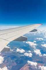 View from the airplane window at a beautiful cloudy sky and the airplane wing