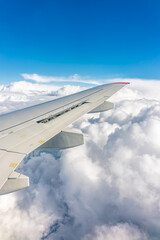 Obraz premium View from the airplane window at a beautiful cloudy sky and the airplane wing