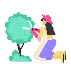 Gardener pruning a lush green tree with pink gloves and hat