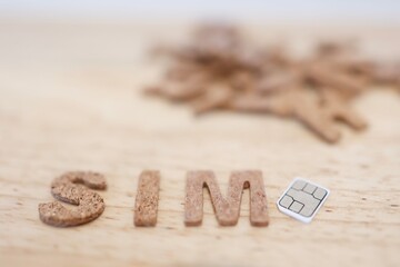 SIMカードとコルク製アルファベット文字SIMのイメージ。