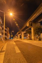 オレンジ色の街灯が明るい深夜のモノレールのレールと道路