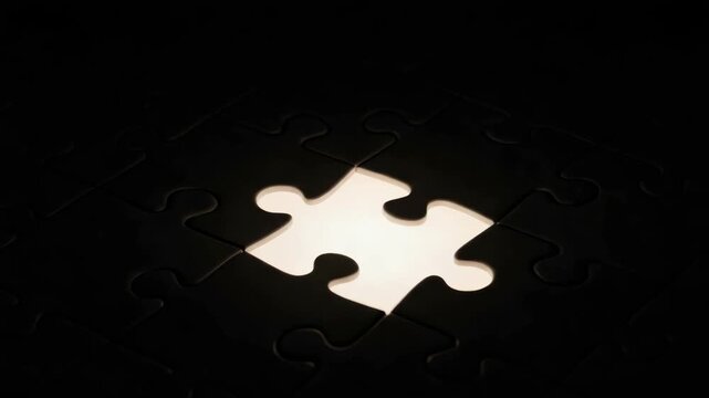 dark puzzle board entirely black features central missing piece This void emits bright soft white light illuminating the immediate textured edges of the dark surrounding pieces symbolizing key discove