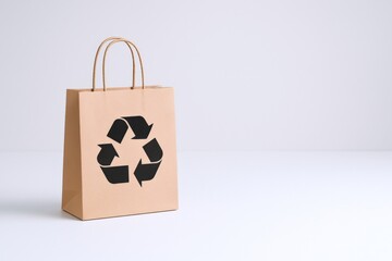 Eco-Friendly Brown Paper Shopping Bag with Recycle Symbol on White Background Promoting Sustainability