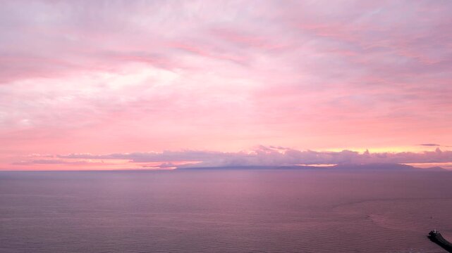 Drone aerial view over the coastline of Ayr in Scotland at dusk, Arran views