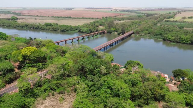 Drone view of Rio Pardo river with bridge and preserved native vegetation in Barretos and Gua&iacute;ra, S&atilde;o Paulo, Brazil