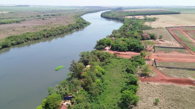 Drone view of Rio Pardo river with bridge and preserved native vegetation in Barretos and Gua&iacute;ra, S&atilde;o Paulo, Brazil