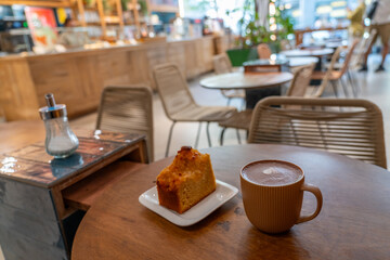 A slice of cake and a cup of coffee on a table. wide angle