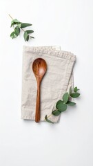 Spoon, cloth, and leaves on white