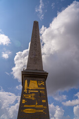 Fototapeta premium Obelisk with hieroglyphs and engravings against a cloudy sky.