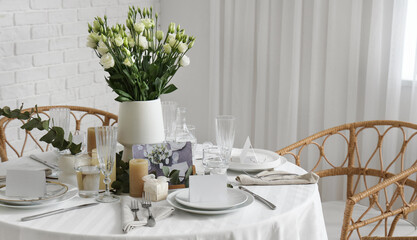 Beautiful table setting with eustoma flowers and candles for wedding celebration in room