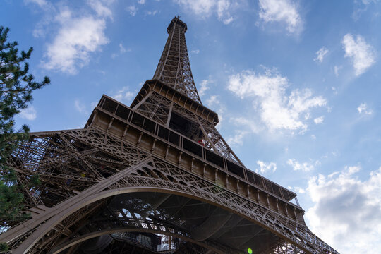 Eiffel Tower against a blue sky with clouds. - Powered by Adobe