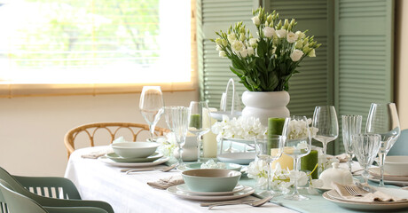 Beautiful table setting with white flowers for wedding celebration in room