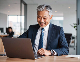 ノートパソコンを見て喜ぶ部長クラスのビジネスマン