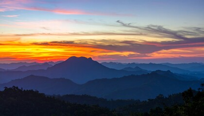 Colorful sunset over layered mountain silhouettes