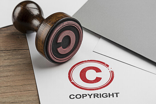 Copyright stamp on paper with a wooden handle ensuring intellectual property and legal protection