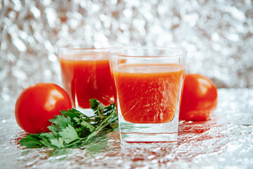 Red tomato juice with green parsley on the glittering silver background, food card 
