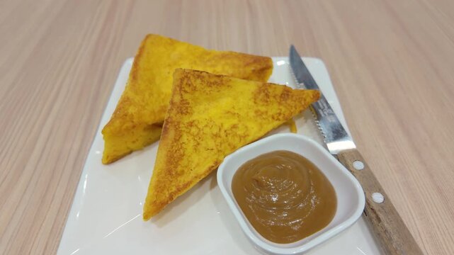 Egg toast with kaya and spreader on the plate
