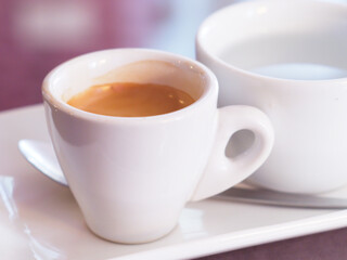 Cup of coffee and cappuccino with milk on white saucer for breakfast beverage