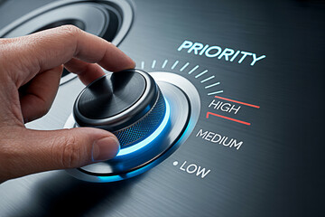 Hand turning a priority knob to high setting showing focus and importance in decision making process
