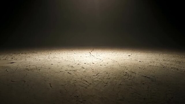 Dimly lit empty space with textured ground, showcasing shadows and subtle patterns