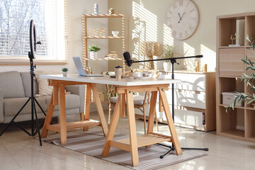 Interior of blogger's office with workplace, laptop, lamp and microphone on wooden table