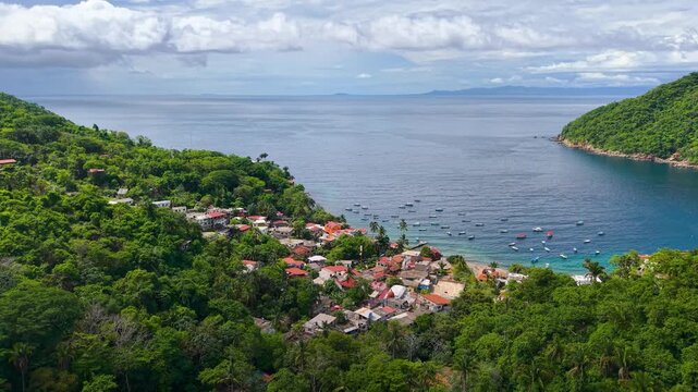 Summer coastal scenery on the beaches of the town of Yelapa, Jalisco, located south of Puerto Vallarta, Mexico, with a blue sea and jungle mountains under a clear sky, perfect for nature trips and tro