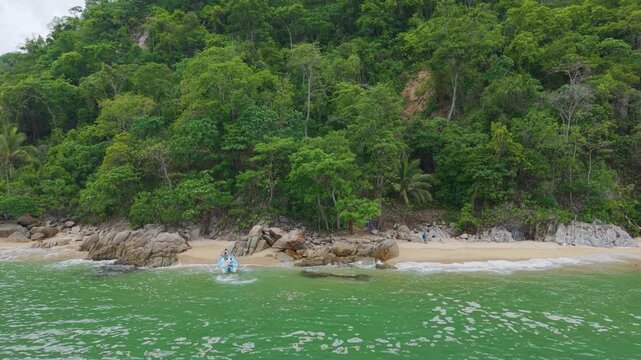 lancha llegando a una hermosa playa del estadode  Jalisco M&eacute;xico.  Toma aerea con dron tipo travelling, playa rodeada de selva.