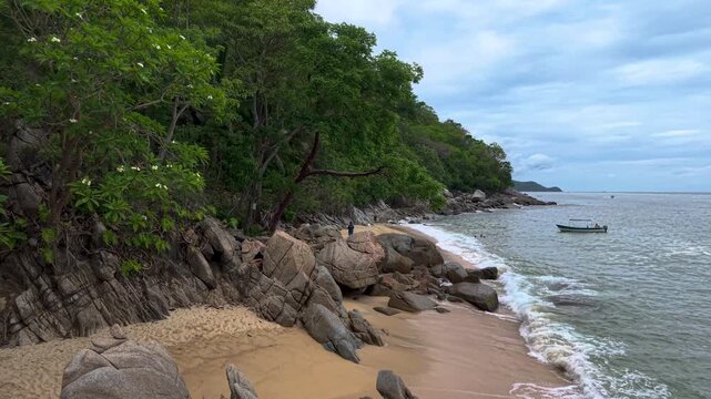Vacaciones de verano en las playas de puerto vallarta Jalisco de arena blanca y mar turquesa con olas suaves y selva, rocas gigantes en la orilla de la playa enterradas