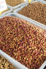 Variety of colorful pet food in bulk bins at a market