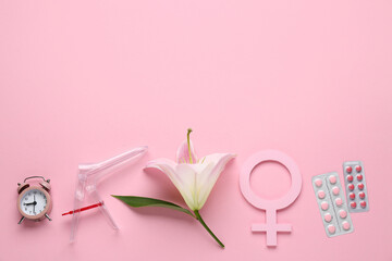 Gynecological speculum with orchid flower, symbol of woman, alarm clock and pills on pink background