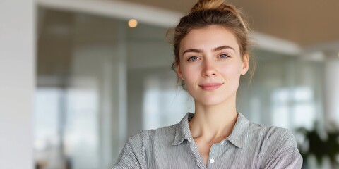 Young professional woman smiling in a modern office environment during daytime.