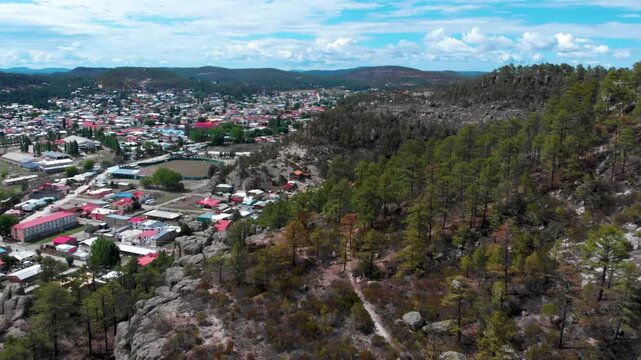 Poblado de creel chihuahua rodeado de bosque verde, toma aerea desde un drone en el verano