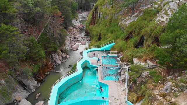 toma aerea Zoom out con dron de las Aguas termales de Recowata al sur del pueblo de Creel en Chihuahua M&eacute;xico

