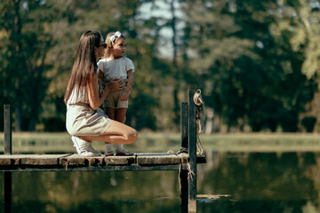 Mother and daughter spending quality time together by the lake on a peaceful summer day