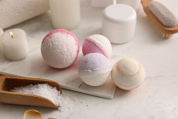 Composition with tray, bath bombs and scoop with sea salt on white grunge background, closeup