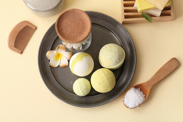 Composition with tray, bath bombs and plumeria flower on yellow background