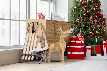 Sled with ice skates and Christmas reindeer in living room interior