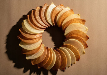 Dried orange peel crescents layered into a tight spiral on brown paper, warm citrus pattern for healthy dessert ideas, recipe cards and artisanal culinary branding