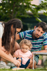 Naklejka premium Family spending quality time outdoors with their child enjoying playful activities together in a relaxed and loving atmosphere.