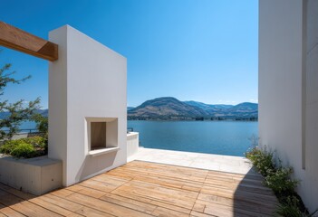 A contemporary outdoor space with a white wall, wooden decking, and lake views.  The design features a fireplace niche with a serene vista.