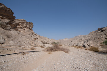 Scenic landscapes and mountain roads around Jebel Hafeet in Al Ain, United Arab Emirates, showing desert terrain, rocky hills, and winding routes under clear skies.