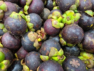 Pile of mangosteen fruit displayed in grocery store