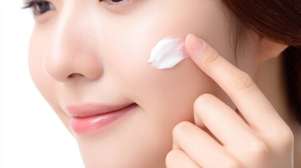 Woman applies face cream for hydrated skin, female carefully applies nourishing cream to her delicate facial skin.