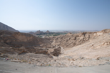 Scenic landscapes and mountain roads around Jebel Hafeet in Al Ain, United Arab Emirates, showing desert terrain, rocky hills, and winding routes under clear skies.