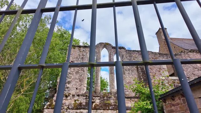 Camera pullout from Beauport Abbey in Paimpol, France&mdash;Gothic ruins framed by coastal gardens, forest edge, and the Bay of Launay in a layered monastic and maritime landscape
