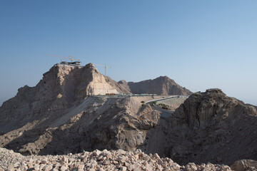 Scenic landscapes and mountain roads around Jebel Hafeet in Al Ain, United Arab Emirates, showing desert terrain, rocky hills, and winding routes under clear skies.
