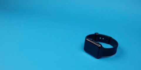 A Sleek Black Smartwatch Resting on a Vibrant Blue Background, Ready for Your Next Technological Adventure