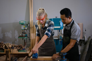 Carpenters are working together at workshop.