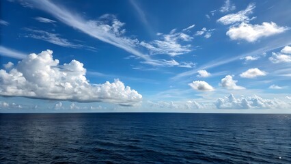 Obraz premium Vast blue ocean meets a sky filled with dramatic white clouds